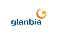 The image shows the Glanbia logo. The logo features the word "glanbia" in blue lowercase letters. To the upper right of the text is a stylized orange and yellow circular design.