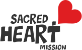 Logo of Sacred Heart Mission featuring the words "Sacred Heart" in block letters, with "Mission" in smaller text below. A large red heart design is positioned to the right of the text.